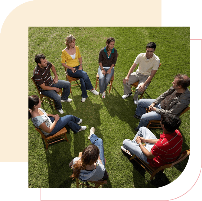 A group of people sitting in the grass