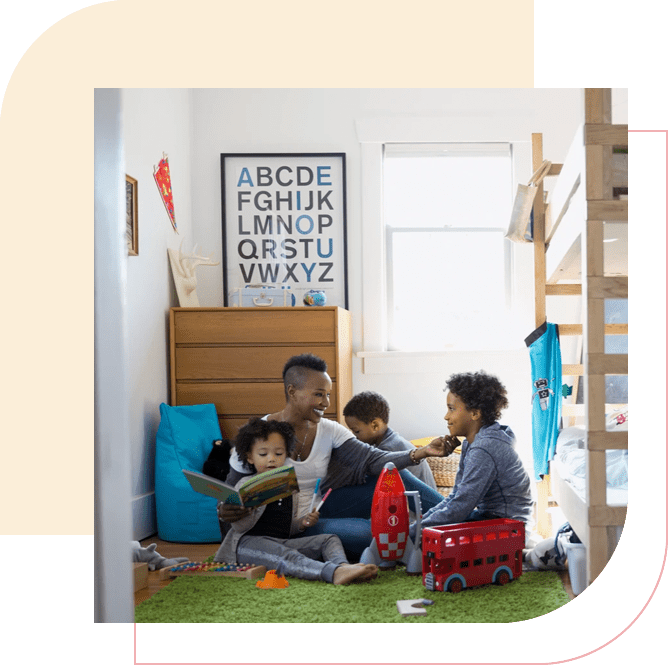 A family sitting on the floor in their room