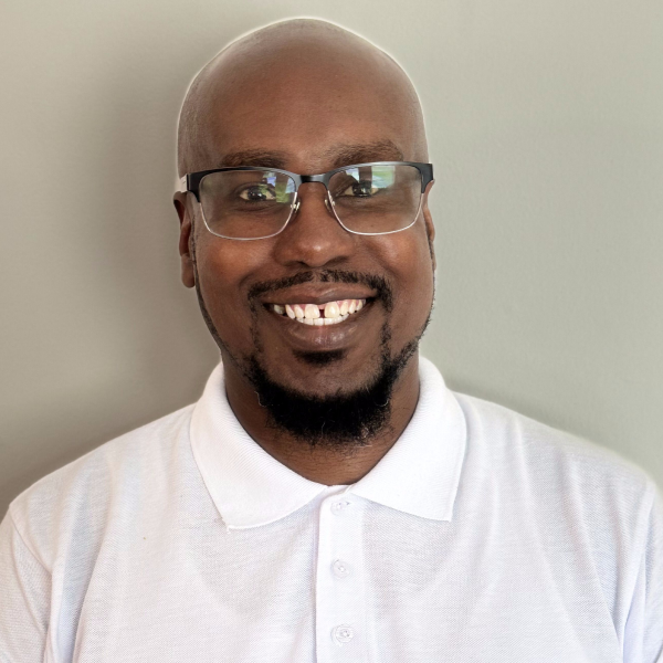 A man with glasses and bald head smiling.